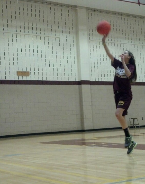 Shoot for the stars: Caroline Peterson (9) shoots a layup in her second period gym class. Coach Kaylisz has been working with these 9th graders, teaching them proper techniques for shooting a basketball. “I just like shooting” said Caroline. Coach K later went on to teach dribbling skills.