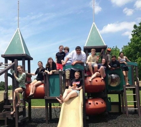 High school members of the cast pose for a photo, taking a break on the playground during an 8 hour rehearsal. 