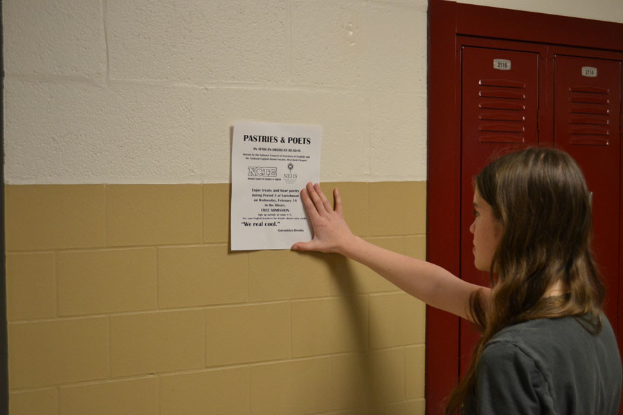 Abby Laporte ('15) posts flier for an African- American read-in. National English Honor Society planned this event for Black History.