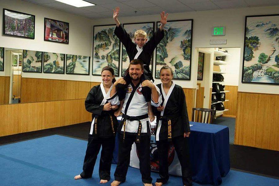 Alex Trikeriotis ('18) poses with her friends at Quest Martial Arts. They just passed their black belt test and received their black belts.