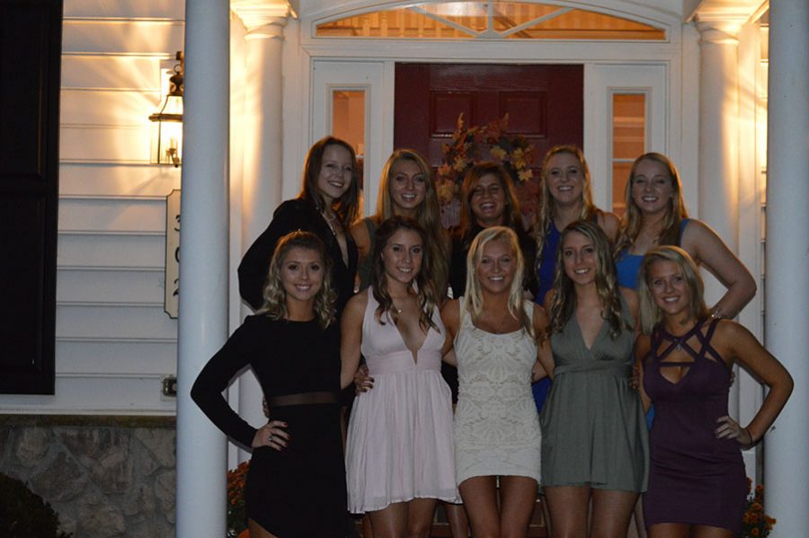 A group of senior girls are taking pictures before homecoming. They smiled for the camera.