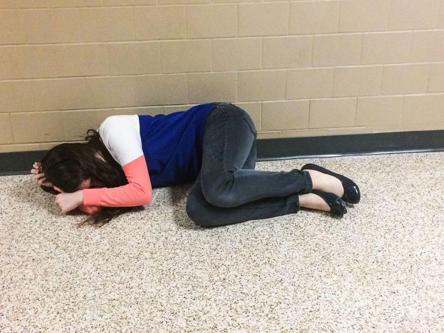 Shaina Lee ('17) lies down in the hallway out of apathy and fatigue, as senioritis has begun taking its toll on students. 