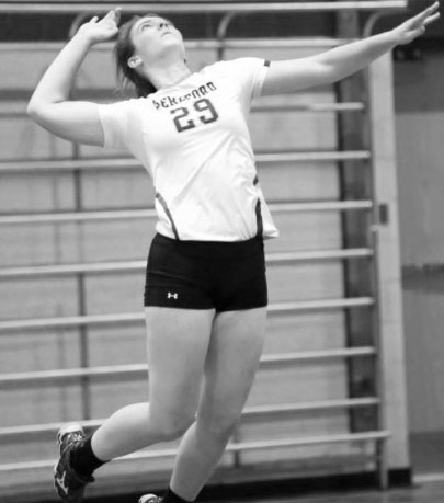 As one of the teams top servers this year, Erin Collins jumps into the air to give a solid serve over the net.
