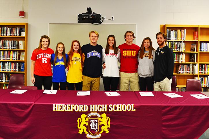 Senior athletes gather in th library on Nov. 11 to sign their national letters of intent. From left to right: Erin Collins, Kelly Wesolowski, Lauren Litsinger, Campbell Carr, Graeme Eber, Andrew Clark, Caroline Peterson, Joey Chesnutt.