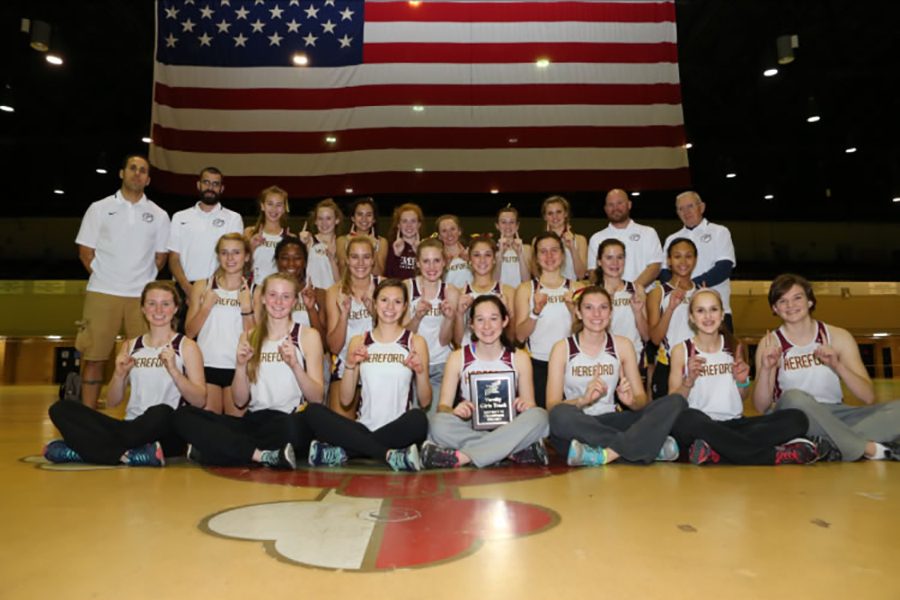 Girls proudly hold plaque for eleventh win in a row.