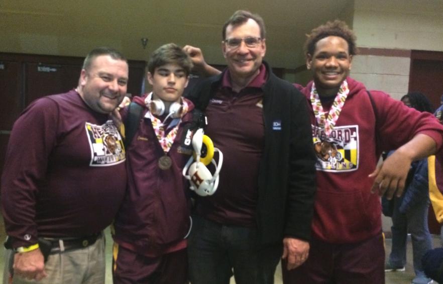 Wrestling Coach Brett Baier, Jimmy Cavin ('17), Coach Ron Causey, and Troy Gladney ('17) stand together for one last picture. Gladney and Cavin wrestled their last matches with the high school team at states on March 5.