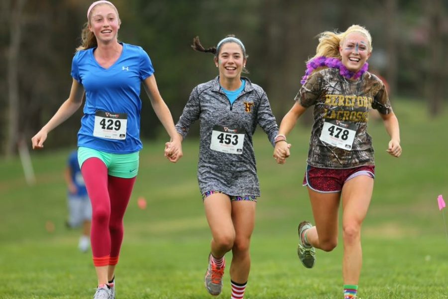 Leighton Eber (19), meredith Joyce (16), and Grace Pfarr (16) have a hoot while jogging at last years CASA run.