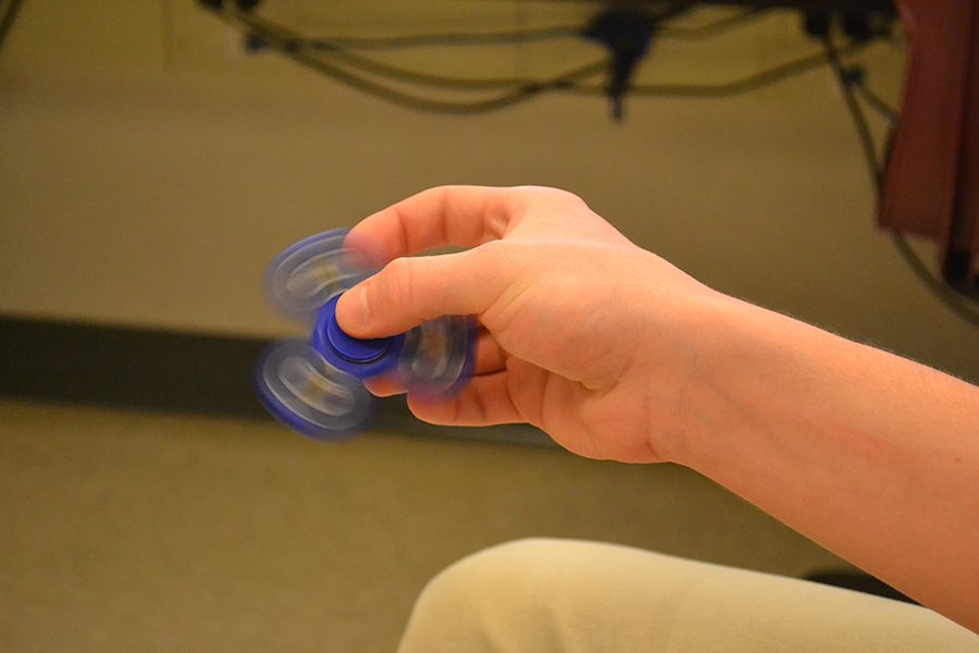 Hugh Lory (17) spins a fidget spinner. The spinner has helped Lory use energy in class and pay attention.