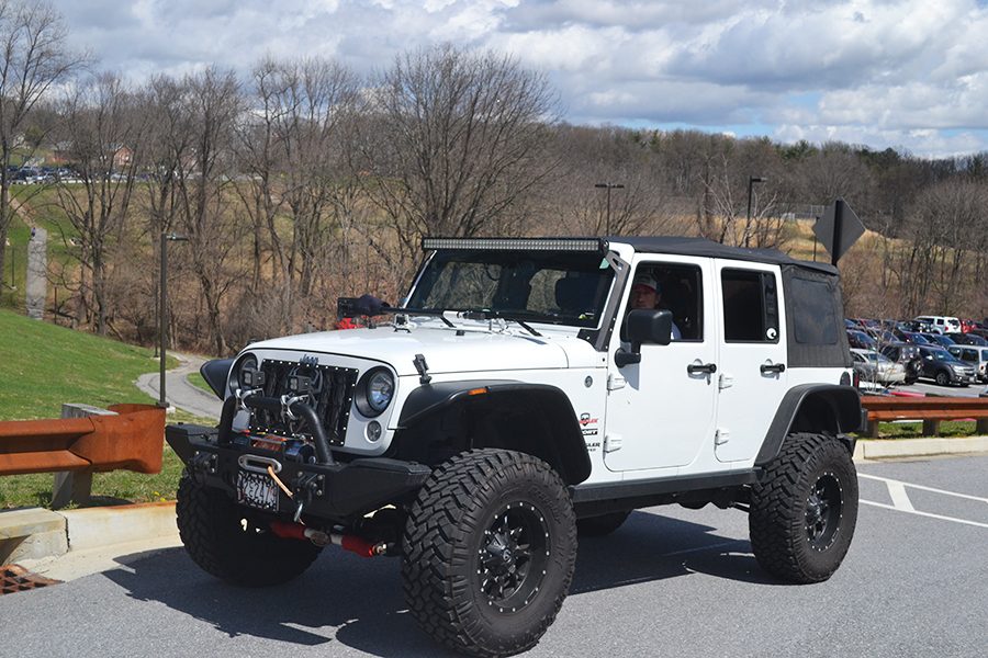 Driving his 2014 jeep Wrangler, Evan Schmidt (17) leaves school. Schmidt bought the car on his own and takes pride in its lights.