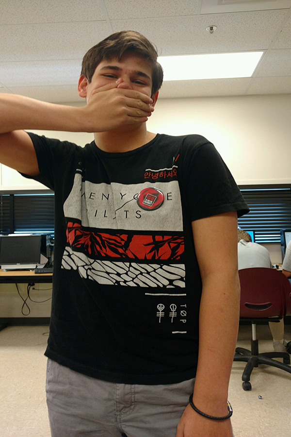 Michael Purdie ('18) stands covering his mouth; Purdie participated in the day of silence among many other students.