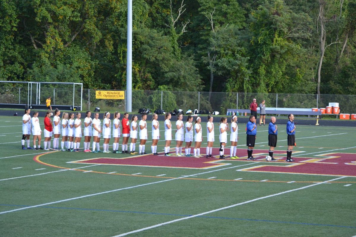 The girls varsity soccer team are standing at mid field, hands on their hearts, mentally preparing for their game against Winters Mill. The girls lost   2-3.