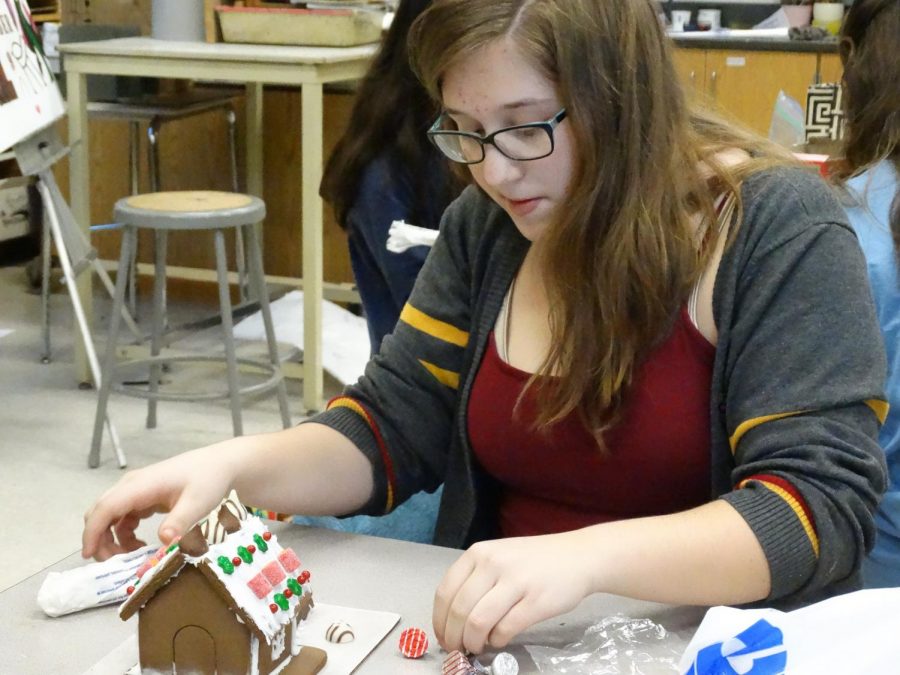 Maddie Gaede (20) decorates her gingerbread house in NAHS. Its just a fun club to be in, Gaede said. 