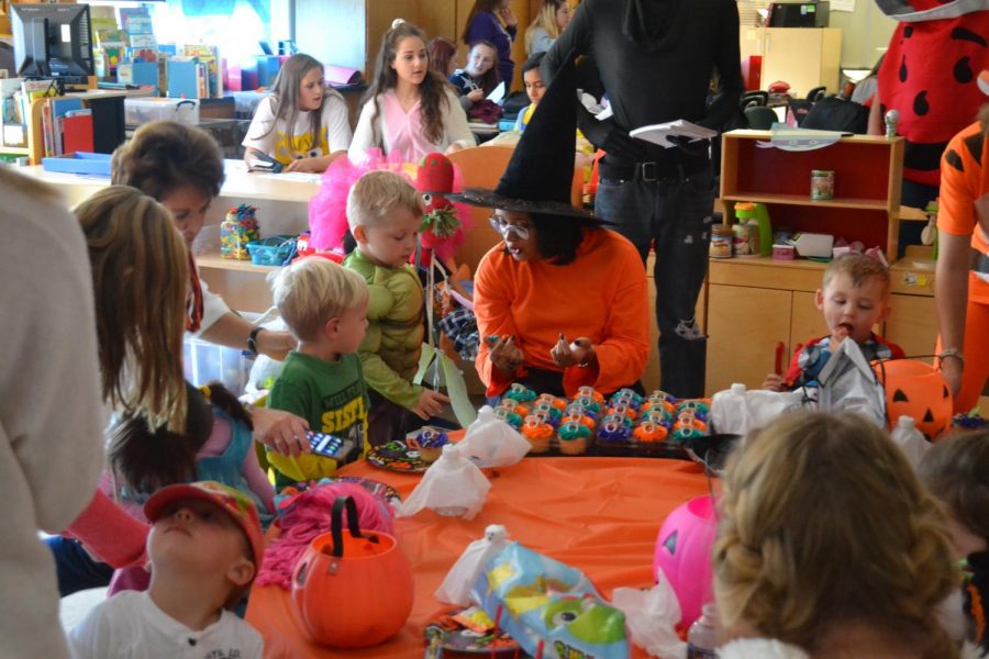 Child Development teacher, Morgan Espeut passes out cupcakes to preschoolers. They had a short break before going on a second round of trick-or-treating. 
I definitely think this [trick-or-treating] will help us with keeping the kids attention and keeping them grounded, said Hannah League (18). 
When youre walking with [the preschoolers] you get to know them better and get a better understanding of their personalities one-on-one. said Sophia Karas (20)