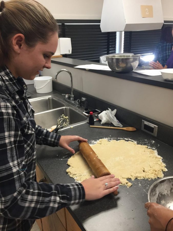 Jenna Field ('19) rolls out sugar cookie dough. Members of the Spanish and French Clubs decorated the cookies for the holiday season.