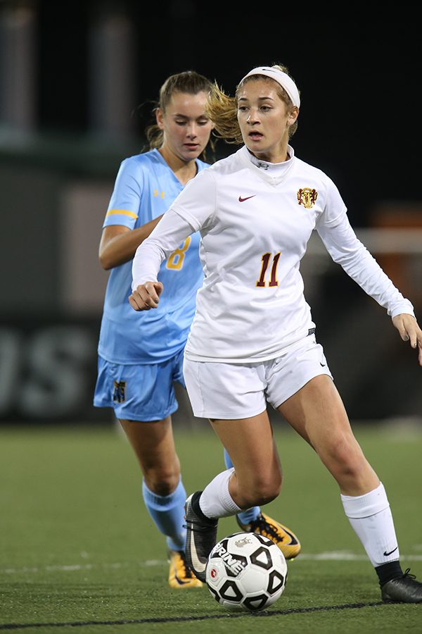 Captain of the soccer team, Schmidt, looks to make a pass to her teammate downfield. 