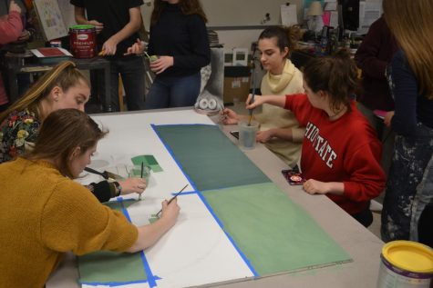 Members of the National Art Honors Society begin to fill the shapes with green paint. The finished panel was portrayed to represent a shall, to embody biology. 