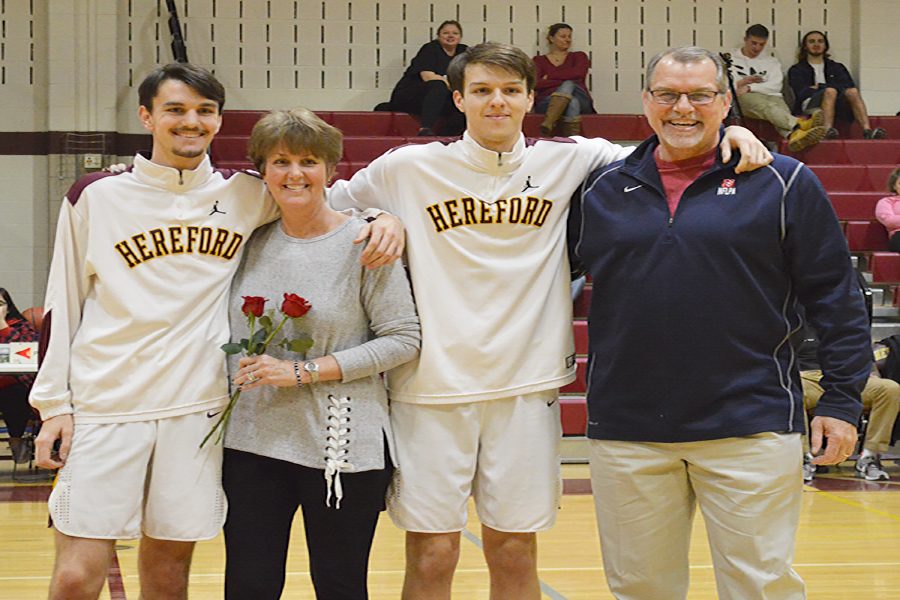 The+Basketball+team+celebrates+parent+night+by+giving+heir+parents+roses+and+hugs.+The+Moritz+family+gathered+at+half-court+to+take+a+picture.+