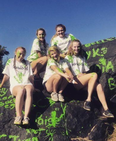 Grace Jung (18), Paige Johnson (18), Emily Levitt (18), Lydia Naughton (18), and Kristen Mitchell (18), celebrate the start of the year at Dulaney High Schools annual senior barbecue. Students have been painting the rock since 1965. 