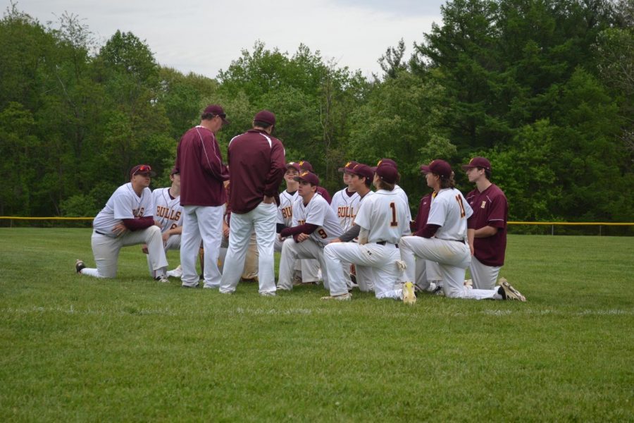 The players huddle around Coach Evans after a home game last season. The team ended with the season with a 14-5 record. 