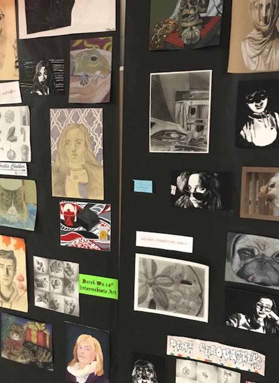 The students' artwork are being displayed on the portfolios. Other pieces of artwork have been hung by the art wing. 