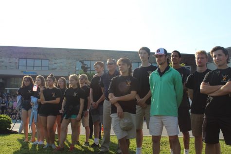 Caption: For Our Troops members stand front row to watch the memorial service. All the members arrived early to help set up chairs and prepare the front of the school to be photo ready. 