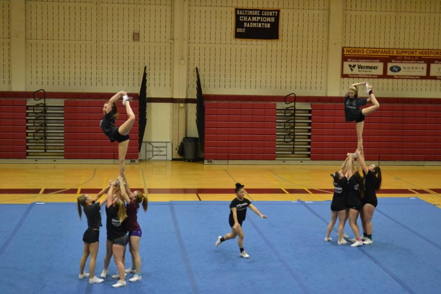 Tumbling through the middle, Sole Bennett (21) gears up to bring her backhand spring jump. Her tumbling skills allowed the squad to incorporate more floor tricks.