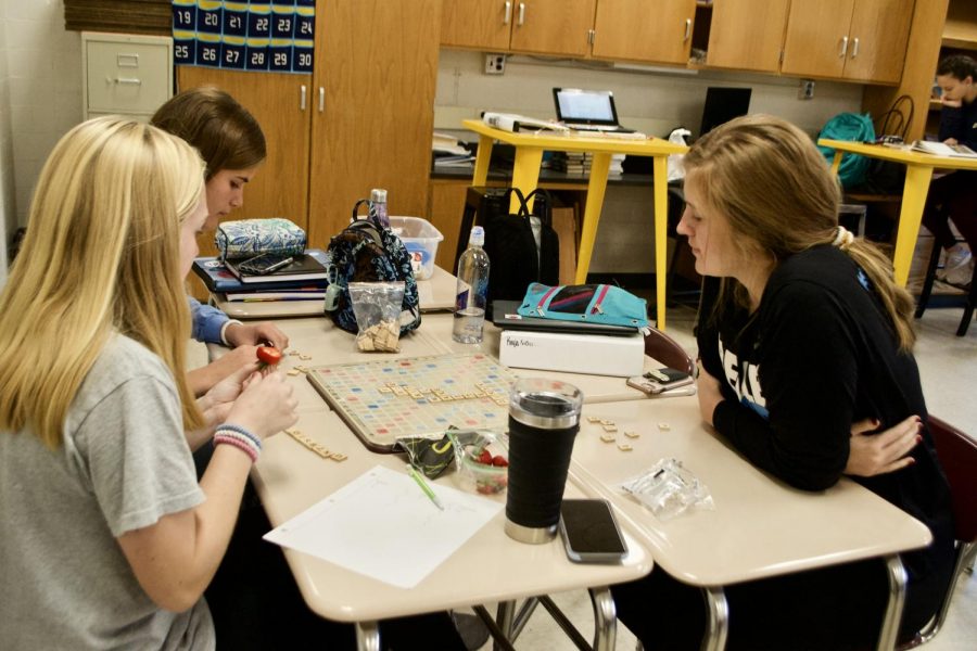 Courtney Craig (22), Kayla Nieberlein (22), and Piper Lentz (22) play a game of Scrabble during one NEHS Monday in Mrs. Vances room. Members were asked to invite other students to the event to play.