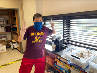 Manuel Grothe (’24) poses for a picture as he makes a coffee in Mrs. Duvall’s room.