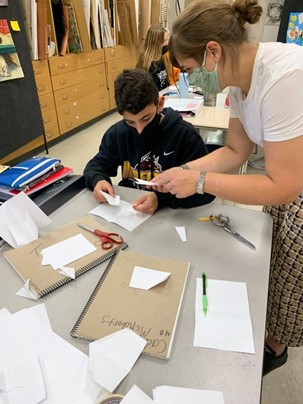 Ms. Souvouvra directs Greg Bara (‘25) on how to fold a pop-up book. He copied Ms. Souvouvra’s directions and successfully folded his pop-up book.