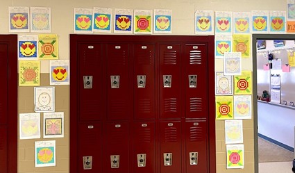 Drawing activities done in Coburns class hung up around the hallway. Students solve problems and find the right color or shape to draw inside the grid.