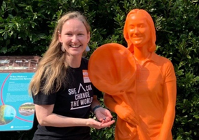 Ronda Hamm poses with her 3D printed statue to celebrate her accomplishments in math and science. 